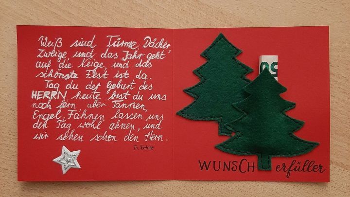 Eine rote Karte mit zwei gr&uuml;nen Tannenb&auml;umen darin, die eine pers&ouml;nliche Weihnachtsnachricht enth&auml;lt.