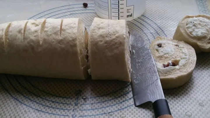 Mit einem unter dem Wasserhahn angefeuchteten Messer wird die Rolle nun in gleichm&auml;&szlig;ig gro&szlig;e Schnecken geschnitten.
