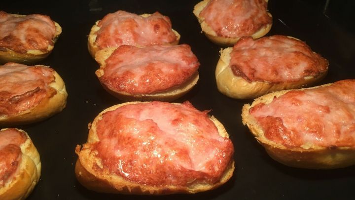 Aufbackbr&ouml;tchen mit Leberk&auml;sbr&auml;t liegen gebacken auf einem Blech und warten darauf, serviert zu werden.