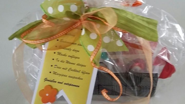 Ein dekoratives Geschenk in Zellophan mit bunten S&uuml;&szlig;igkeiten und einem gr&uuml;n-wei&szlig;en Band, passend als Mitbringsel f&uuml;r jeden Anlass.