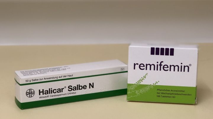 Zwei Verpackungen von pflanzlichen Arzneimitteln stehen auf einem hellen Hintergrund. Halicar Salbe N und remifemin.