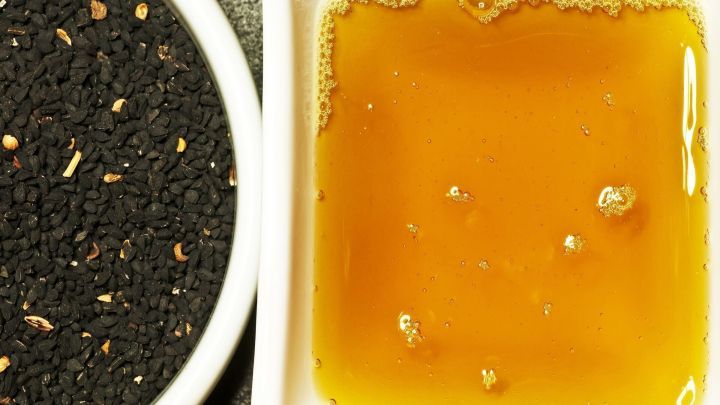 Schwarzk&uuml;mmel&ouml;l in einem flachen Beh&auml;lter neben schwarzen K&uuml;mmelsamen, bereit zur Anwendung f&uuml;r die Fu&szlig;pflege.