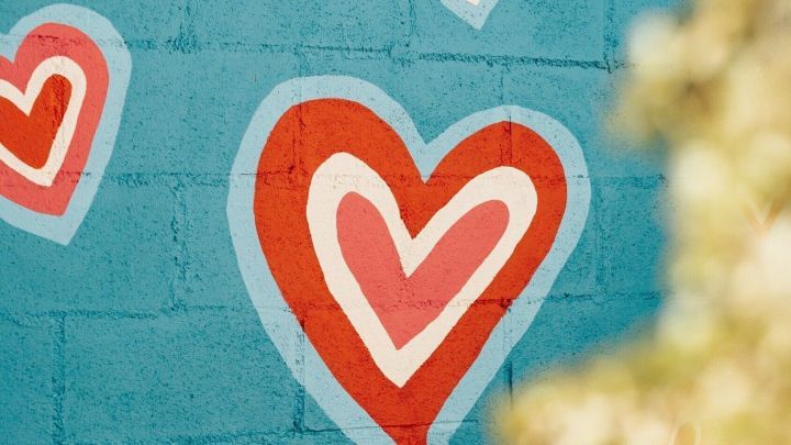 Bunte Herzen schm&uuml;cken eine turquoise Wand, um eine freundliche Atmosph&auml;re zu schaffen, ideal f&uuml;r Gutscheinsysteme.