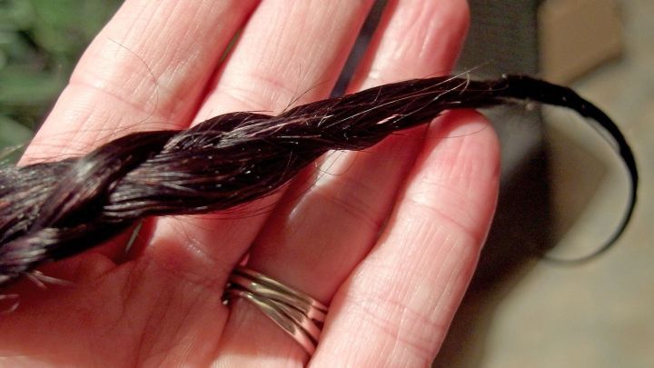 Ein geflochtener Haarzopf liegt sanft in einer Hand, bereit, f&uuml;r die Nacht fixiert zu werden.