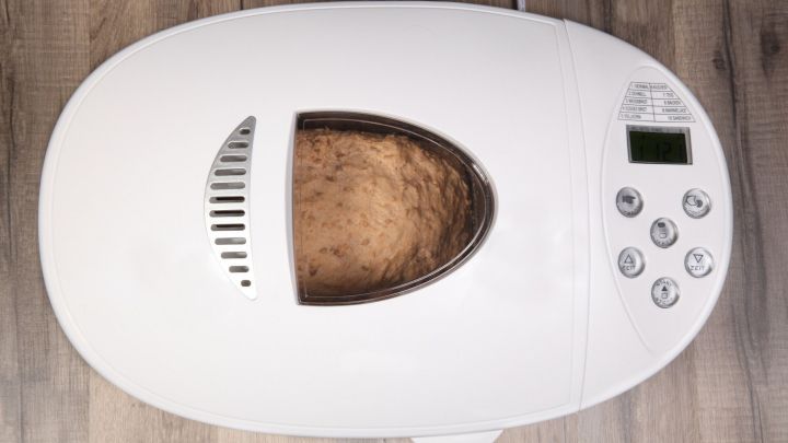 Der Brotbackautomat arbeitet laut knurrend, w&auml;hrend er frischen Teig in einer modernen K&uuml;che zubereitet.