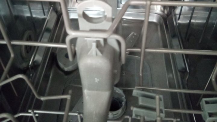 Eine Sp&uuml;lmaschine mit einem sauberen Innenraum zeigt die Sp&uuml;larmstruktur, die bereit ist, schlechte Ger&uuml;che zu entfernen.