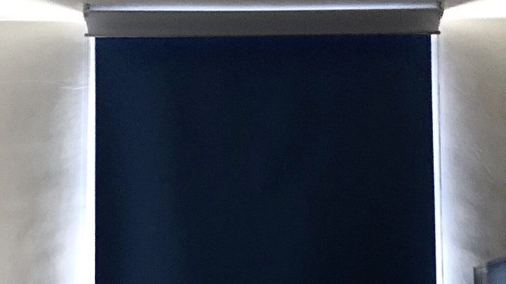 Das Verdunkelungsrollo ist vollst&auml;ndig heruntergelassen und blockiert das Licht in einem Raum mit hellen W&auml;nden.