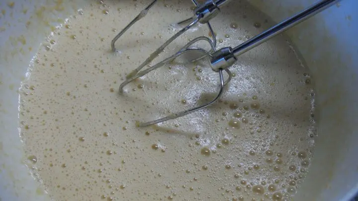 Die Eier werden getrennt, die Eigelbe mit dem Zucker, dem Saft und dem Abrieb der 2 Zitronen schaumig geschlagen, dann rührt man das Öl vorsichtig ein.