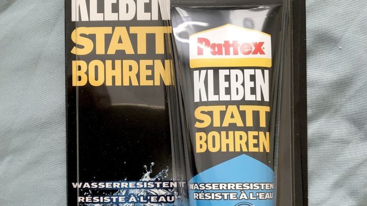 Ein Tubus Montagekleber steht auf einer Verpackung auf einem hellen Hintergrund; ideal zum Reparieren wei&szlig;er Sneaker.