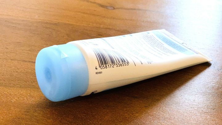 Eine Kosmetiktube liegt auf einem Holzuntergrund. Der Barcode zeigt, dass die CodeCheck-App zum Scannen genutzt werden kann.