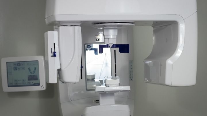 Ein R&ouml;ntgenger&auml;t steht bereit, um Zahnuntersuchungen durchzuf&uuml;hren, w&auml;hrend der Raum klinisch und sauber wirkt.