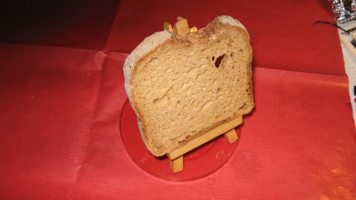 Ein Toastscheibe steht auf einem kleinen St&auml;nder und wird auf rotem Untergrund pr&auml;sentiert, um knusprig zu bleiben.