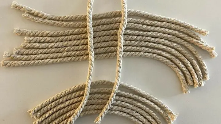 Du ben&ouml;tigst einzelne Kordel-F&auml;den, die du an diesen Steg ankn&uuml;pfst. Bei den gro&szlig;en Federn nehme ich 30 cm lange St&uuml;cke, bei den kleineren Federn sind es etwa 20 cm.