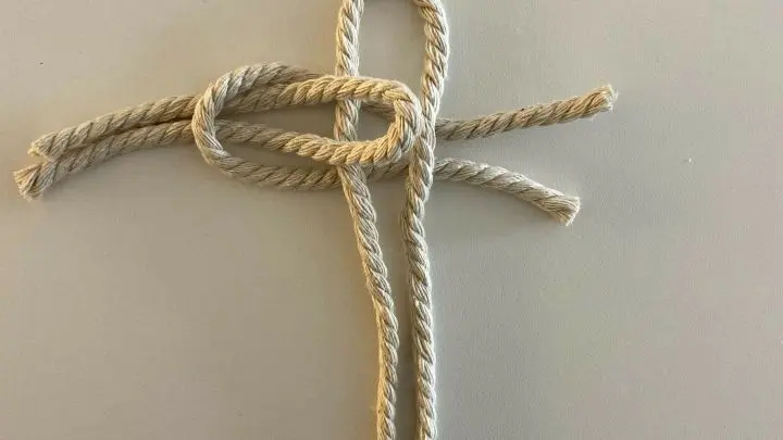 Dann nimmst du ein zweites St&uuml;ck 20-cm-Kordel, formst ebenfalls ein U und f&auml;delst dieses wie auf dem Bild zu sehen durch und befestigst es an der anderen Seite, indem du die Enden des zweiten St&uuml;ckes durchziehst.