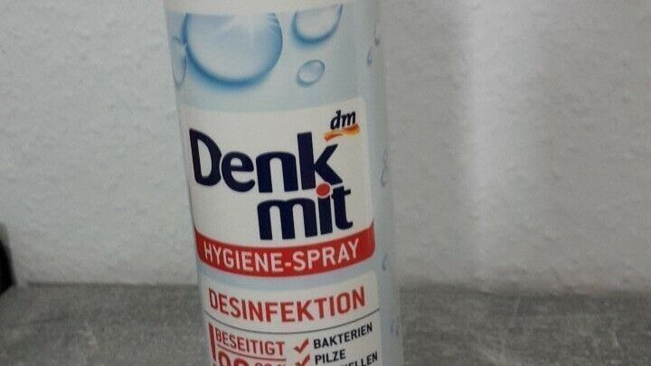 Eine Flasche mit Desinfektionsspray steht auf einer grauen Oberfl&auml;che und k&ouml;nnte zum Entfernen von Haarsprayresten verwendet werden.