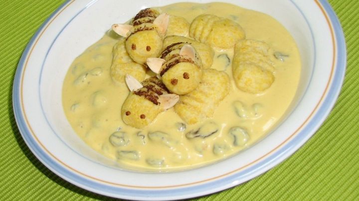 Zarte Kartoffel-Grie&szlig;-Gnocchi liegen in einer cremigen Quarkspeise und sind kunstvoll mit Honigbienen dekoriert.