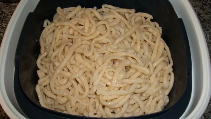 Wenn das Wasser aufkocht und die Spätzle oben schwimmen, dann werden sie mit einem Lochlöffel oder einer Schaumkelle abgeschöpft und in einem Gefäß mit Salzwasser abgeschreckt, dann wieder rausgefischt und in den Sieb-Servierer gegeben.