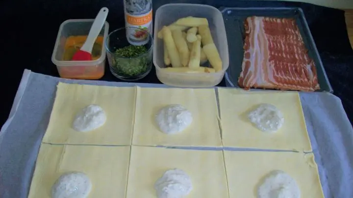 Die R&auml;nder der kleinen Platten werden mit dem verquirlten Ei bestrichen und die Platten selbst bekommen eine etwas glattgestrichene Auflage vom Kr&auml;uterfrischk&auml;se.