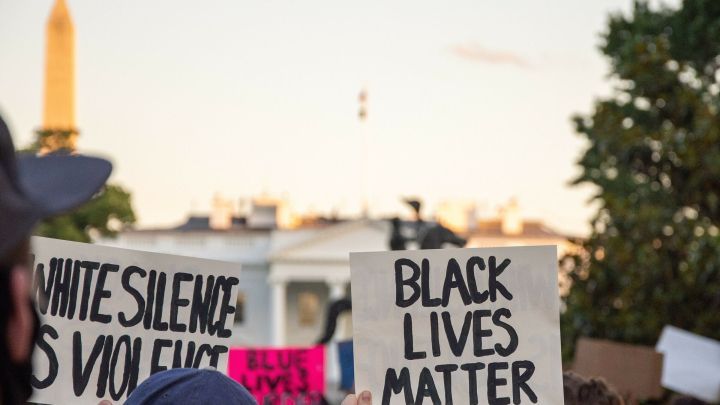 Protestierende halten Schilder hoch, auf denen "BLACK LIVES MATTER" und "WHITE SILENCE IS VIOLENCE" steht, vor dem Wei&szlig;en Haus.