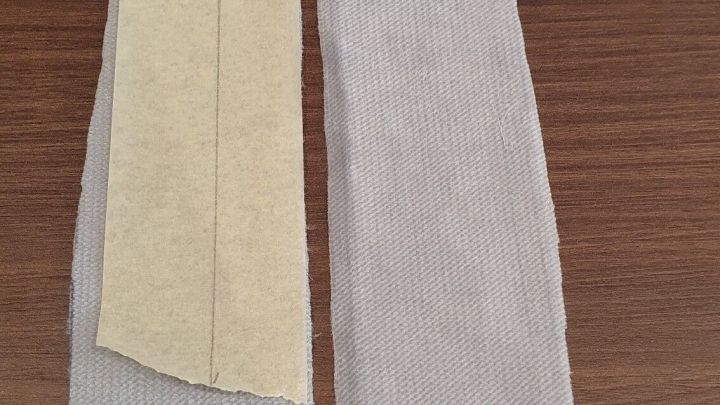 Zwei Reste rutschiger Stoffe liegen neben einem Geodreieck auf einem Holzuntergrund, bereit zum Zusammenn&auml;hen.