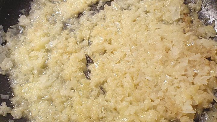 In einer Pfanne braten gehackte Zwiebeln goldbraun, um einen leckeren Geschmack ohne rohe Zwiebeln zu erzielen.