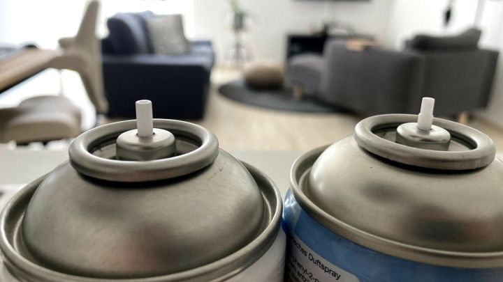 Zwei Spraydosen stehen nebeneinander, bereit zur Verwendung im modernen Wohnraum mit gem&uuml;tlicher Einrichtung.