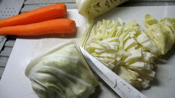 Der Spitzkohl wird zuerst l&auml;ngs geviertelt, dann schneidet man den Strunk heraus und die Viertel in schmale Streifen.   
