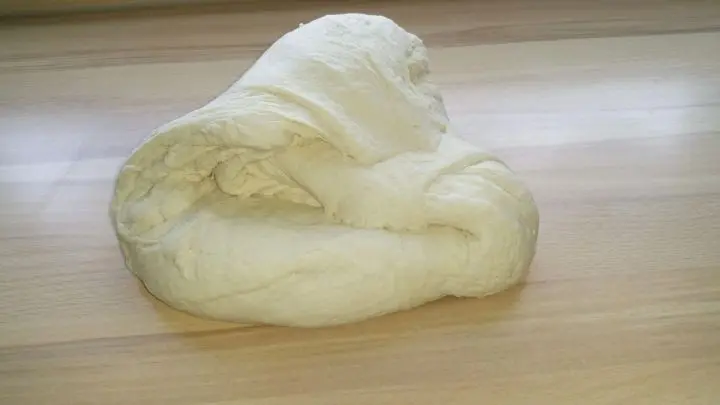 Nun den Teig von Hand kurz durchkneten. Als nächstes daraus zwei Rollen formen und die Teiglinge abstechen.