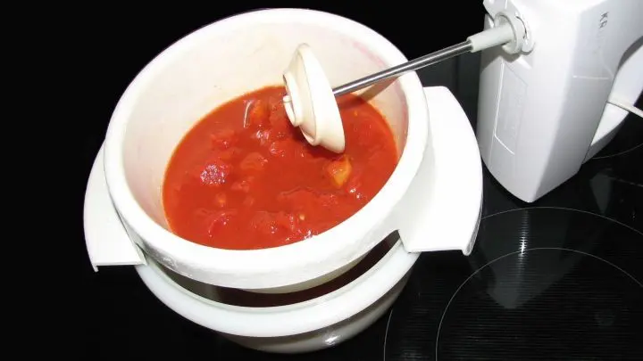Den Doseninhalt in einen schlanken hohen Mixbecher umfüllen und mit dem Schnellmixstab pürieren, danach in ein Sieb geben und passieren.