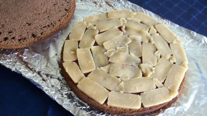 Um den ersten Boden wird ein Kuchenring gespannt und die Marzipandecke oder das in Scheiben geschnittene Rohmarzipan wird auf diesem unteren Boden gleichm&auml;&szlig;ig aufgelegt bzw. verteilt.