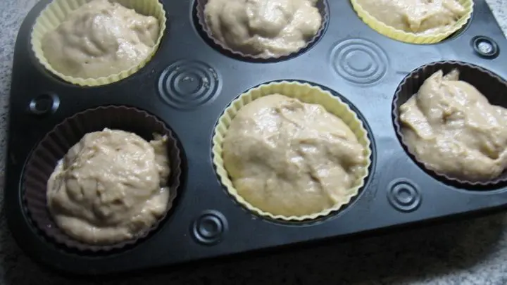 Den Teig verteilt man in die Muffinf&ouml;rmchen, f&uuml;llt diese aber nicht ganz.