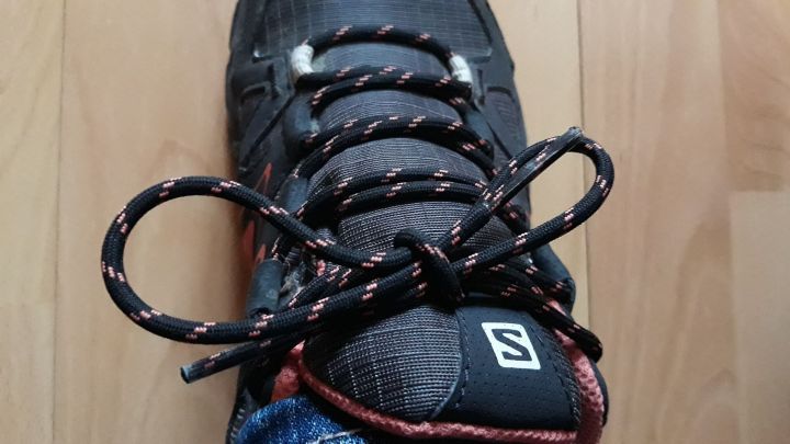 Ein einzelner Schuh mit Schn&uuml;rsenkeln steht auf einem Holzboden, w&auml;hrend die lockeren Schn&uuml;rsenkel beim Gehen drohen, sich zu l&ouml;sen.