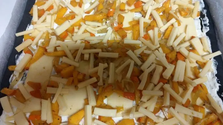 Zum Schluss den geriebenen K&auml;se auf der Pizza verteilen. Die Pizza in den vorgeheizten Backofen schieben und 10-15 Minuten backen. 