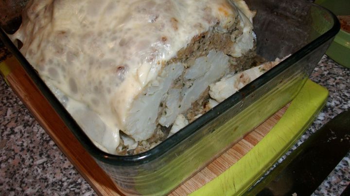 Ein &uuml;ppig &uuml;berbackener Blumenkohl liegt in einer Glasform, umh&uuml;llt von einer K&auml;sekruste, bereit f&uuml;r den Genuss.