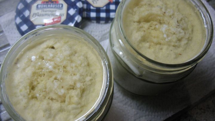 Zwei Gl&auml;ser Kohlpaste stehen auf einer K&uuml;chenoberfl&auml;che, w&auml;hrend das cremige, beige Produkt oben sichtbar ist.