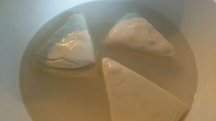 Die Teigecken werden in der vorbereiteten Natronlauge kurz gebadet.