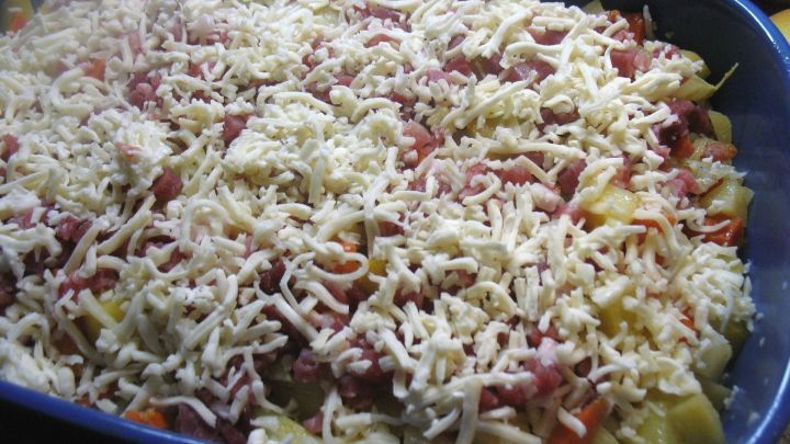 Das vorgegarte Gem&uuml;se gibt man in die Auflaufform, gie&szlig;t die Sahne dar&uuml;ber und verteilt die Schinkenw&uuml;rfel und den geriebenen K&auml;se dar&uuml;ber.