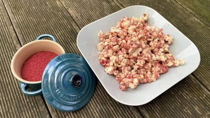 Hier sieht man das fertige Popcorn und daneben die dafür verwendeten roten Kuchenkrümel.