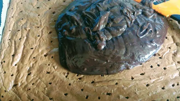 Die Kuvert&uuml;re auf dem Brownie verstreichen und mit den gehobelten Mandeln bestreuen.