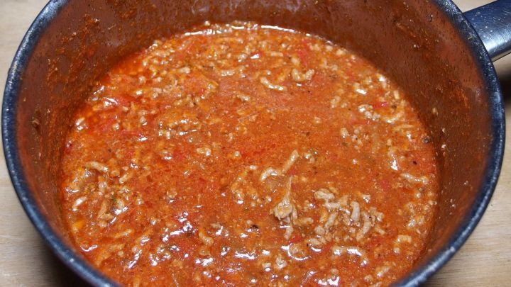 In einem Topf simmert eine dicke Hackfleischso&szlig;e, rot und aromatisch, bereit zum Servieren.