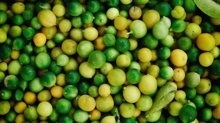 Lebensmittel in verschiedenen Gr&uuml;nt&ouml;nen liegen eng beieinander, wobei die gelben Zitrusfr&uuml;chte hervorstechen.