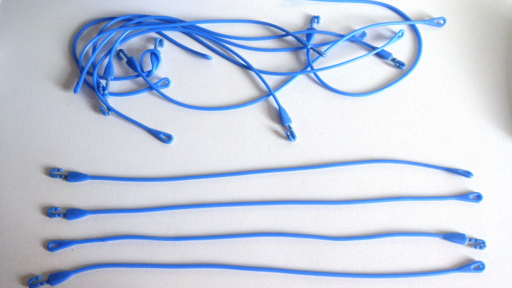 Silikon-Bratschn&uuml;re liegen ordentlich auf einer hellen Oberfl&auml;che, w&auml;hrend einige lose umherliegen und bereit zur Verwendung sind.