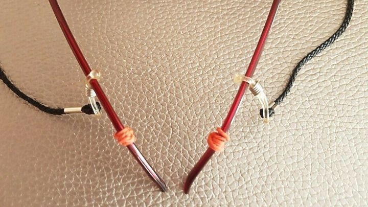 Eine Brille liegt auf einer weichen Oberfl&auml;che, mit einem stabilen Brillenband, das sicher am B&uuml;gel befestigt ist.