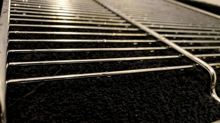 Ein gl&auml;nzender Backofenrost liegt auf einem schwarzen Tuch und gl&auml;nzt leicht feucht nach der Reinigung.
