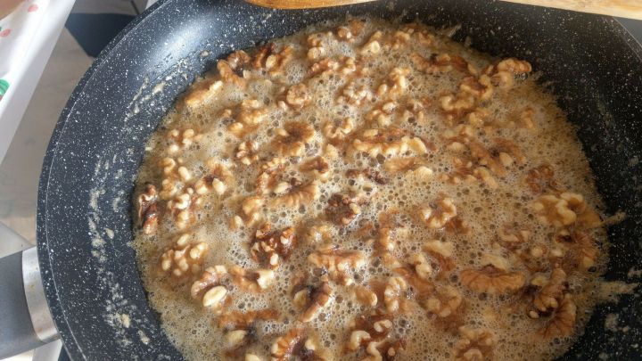 In einer Pfanne den Zucker in der Butter schmelzen lassen. Die gehackten Waln&uuml;sse zuf&uuml;gen und kurz karamellisieren lassen.