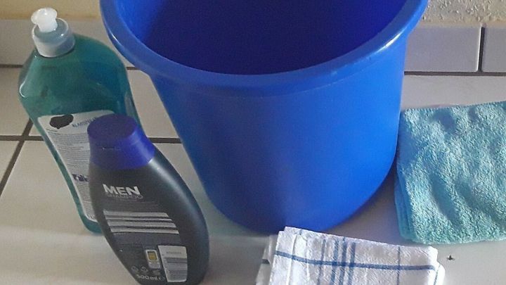 Ein blauer Eimer steht bereit, um mit Reinigungsmitteln das Fensterputzen flink & sauber zu erleichtern.