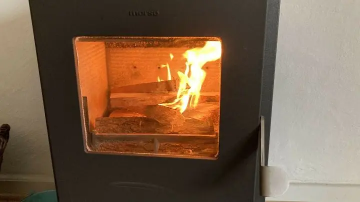 Am Anfang ist die Tür des Ofens noch einen Spalt breit geöffnet, damit mehr Luft an das angezündete Holz gelangt. Diese wird geschlossen, sobald die oberen Hölzer gut brennen.