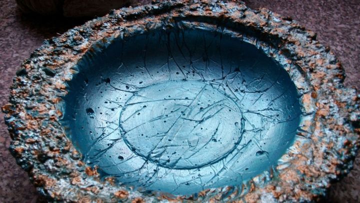 Eine dekorative Vogeltr&auml;nke aus Beton steht auf einer Oberfl&auml;che, bereit, V&ouml;gel im Garten zu erfrischen.