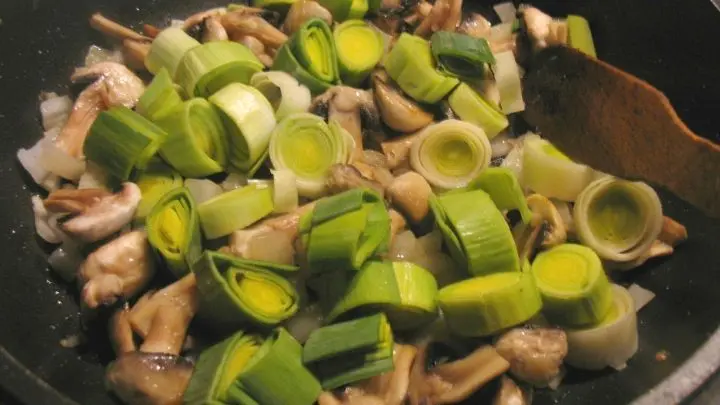Zu den Champignons gibt man die Lauchringe und das Ganze wird unter Wenden weitere 5 Minuten gebraten.