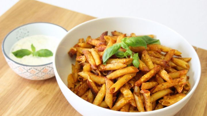 Krosse Pasta Chips liegen in einer wei&szlig;en Sch&uuml;ssel, begleitet von einer cremigen Dip-Sauce in einer kleinen Schale.